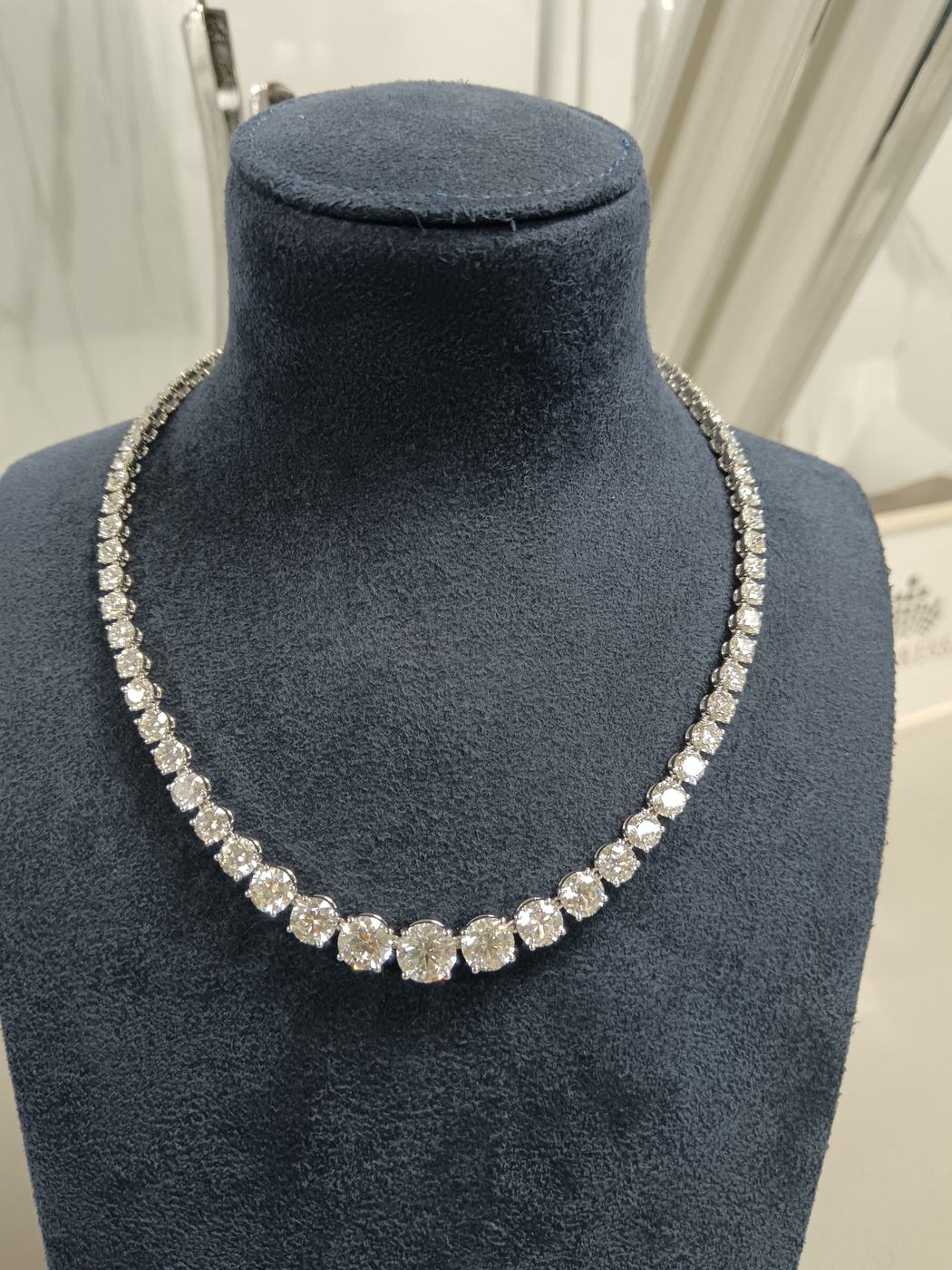 Graduated diamond riviera necklace on a velvet bust